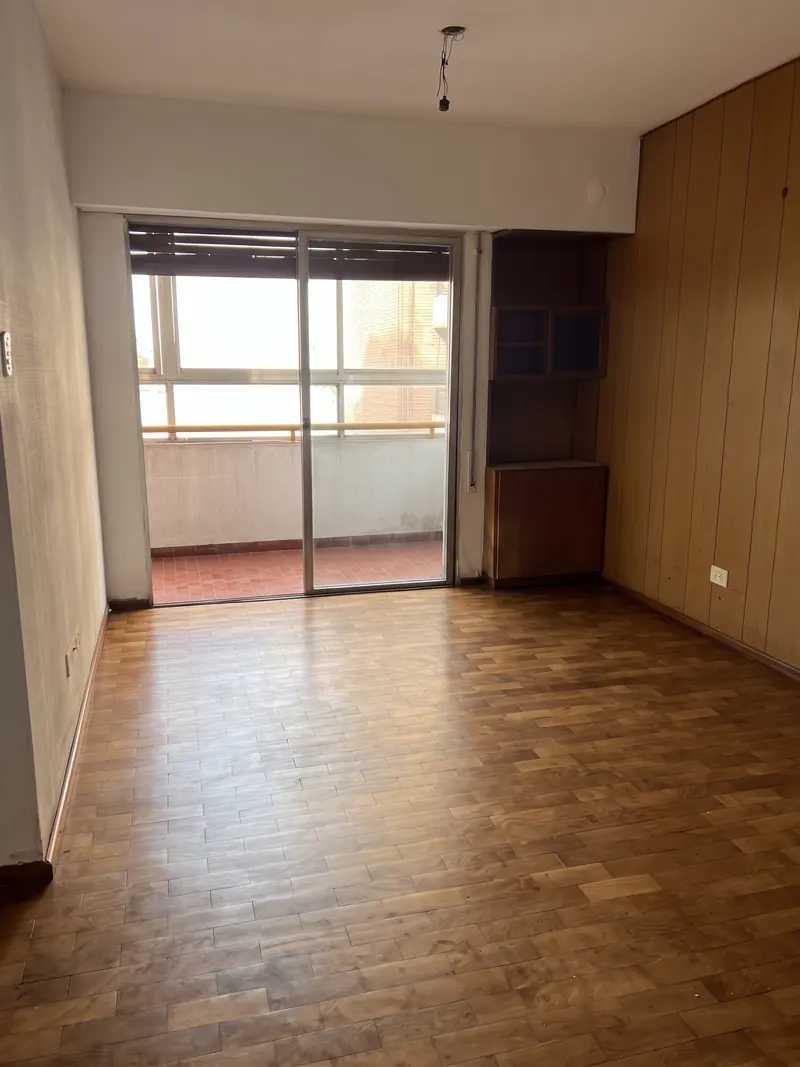 Living comedor con piso de parquet y balcón cerrado de San Juan 468, Barrio Martin